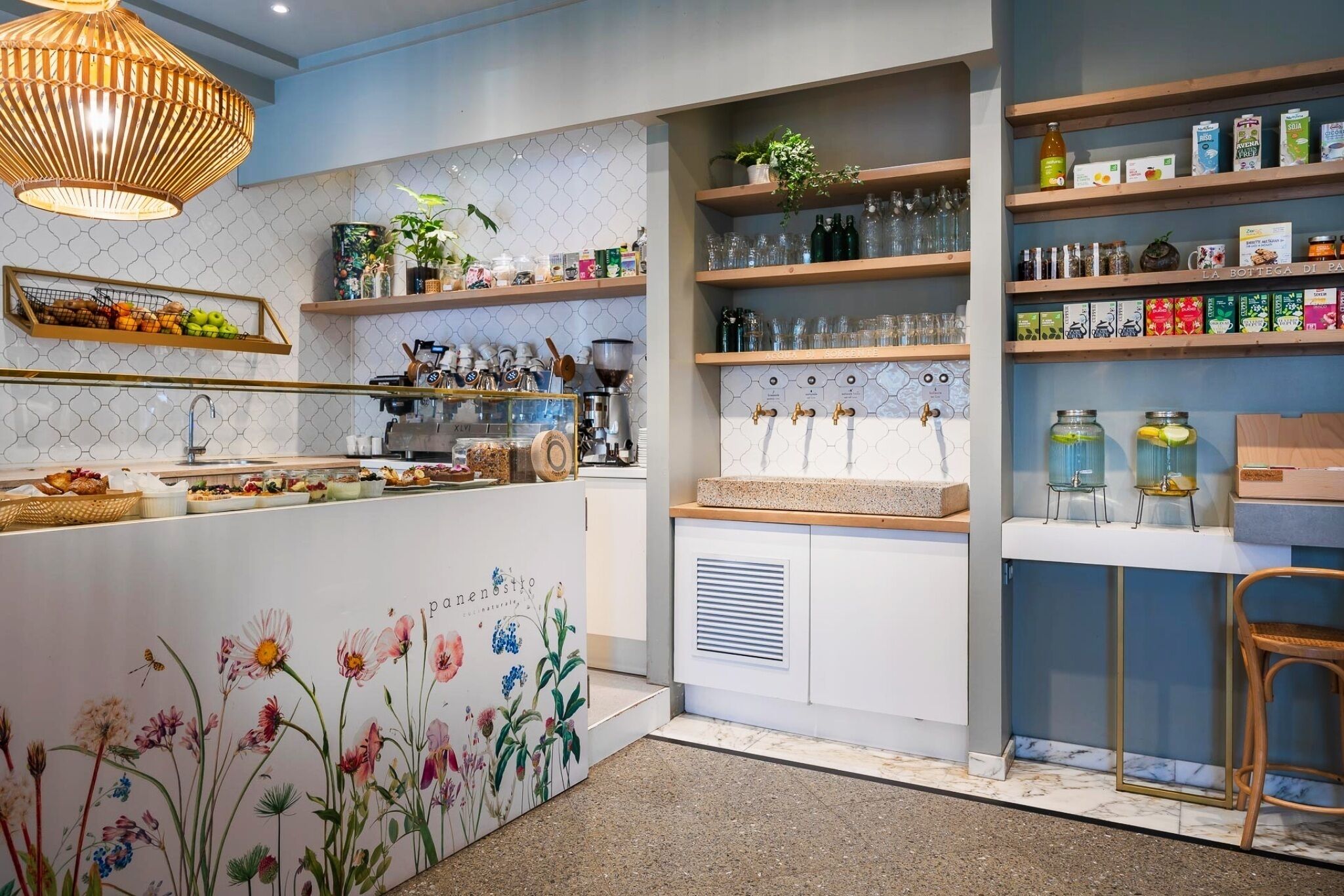 A modern kitchen with a central island, wooden shelves, and a variety of kitchenware and appliances.