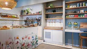 A modern kitchen with a central island, wooden shelves, and a variety of kitchenware and appliances.