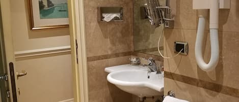 A bathroom with a sink, mirror, and towel rack.