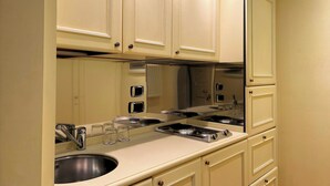 A kitchen with a large mirror, stainless steel appliances, and beige cabinetry. - TORRE DELL'OROLOGIO SIGNATURE RESIDENCE (Venice)