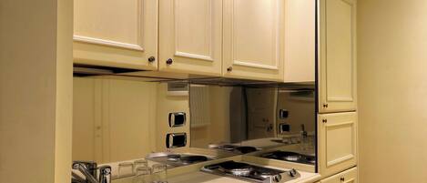 Una cocina con un espejo grande, electrodomésticos de acero inoxidable y muebles color beige.