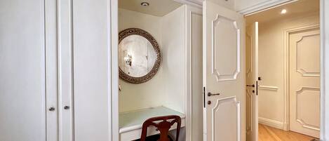 A room with a desk, chair, and a mirror on the wall.