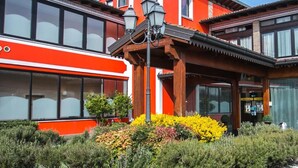 A building with large windows, a red and white facade, and a wooden pergola. - Primotel (Brescia)