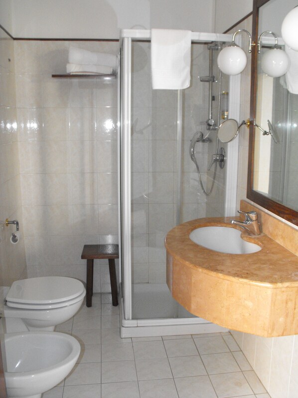 Un baño con ducha, inodoro y lavabo.