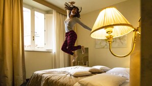 A room with a bed, a lamp, and a window with curtains. - Hotel La Locanda (Volterra)