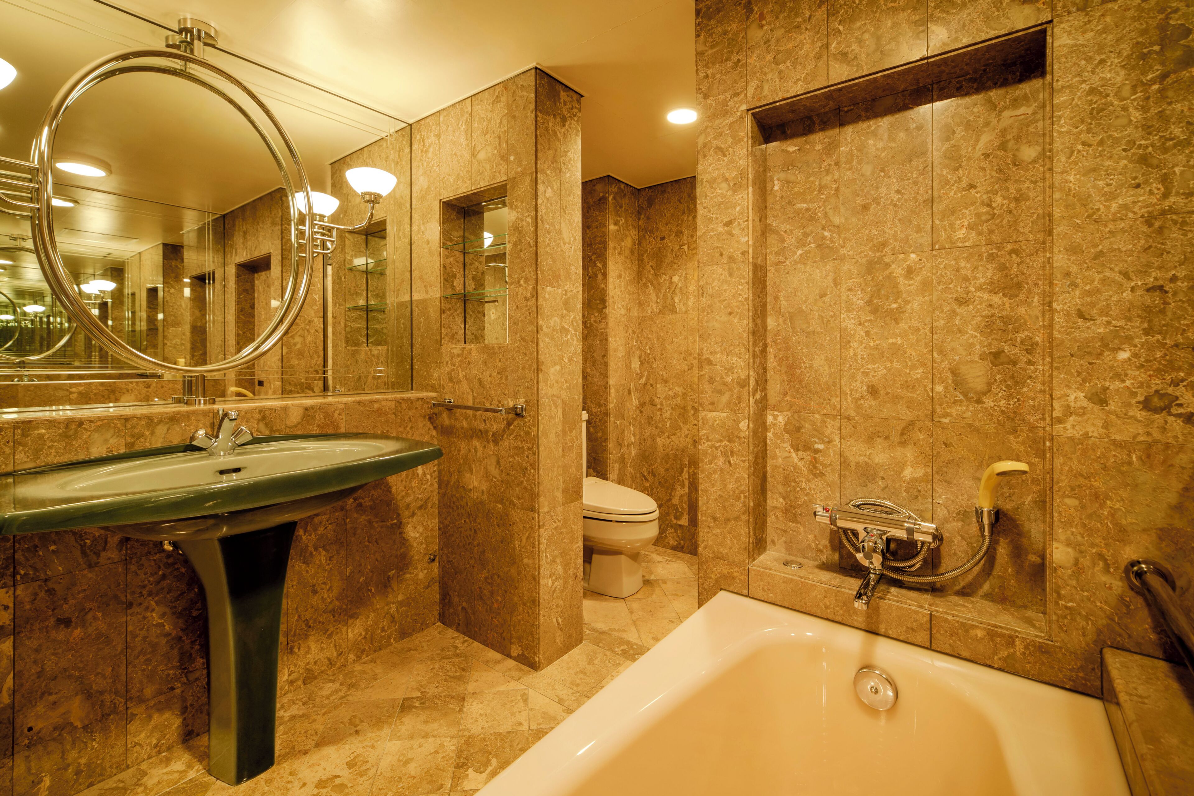 Un baño con lavamanos, inodoro y bañera.