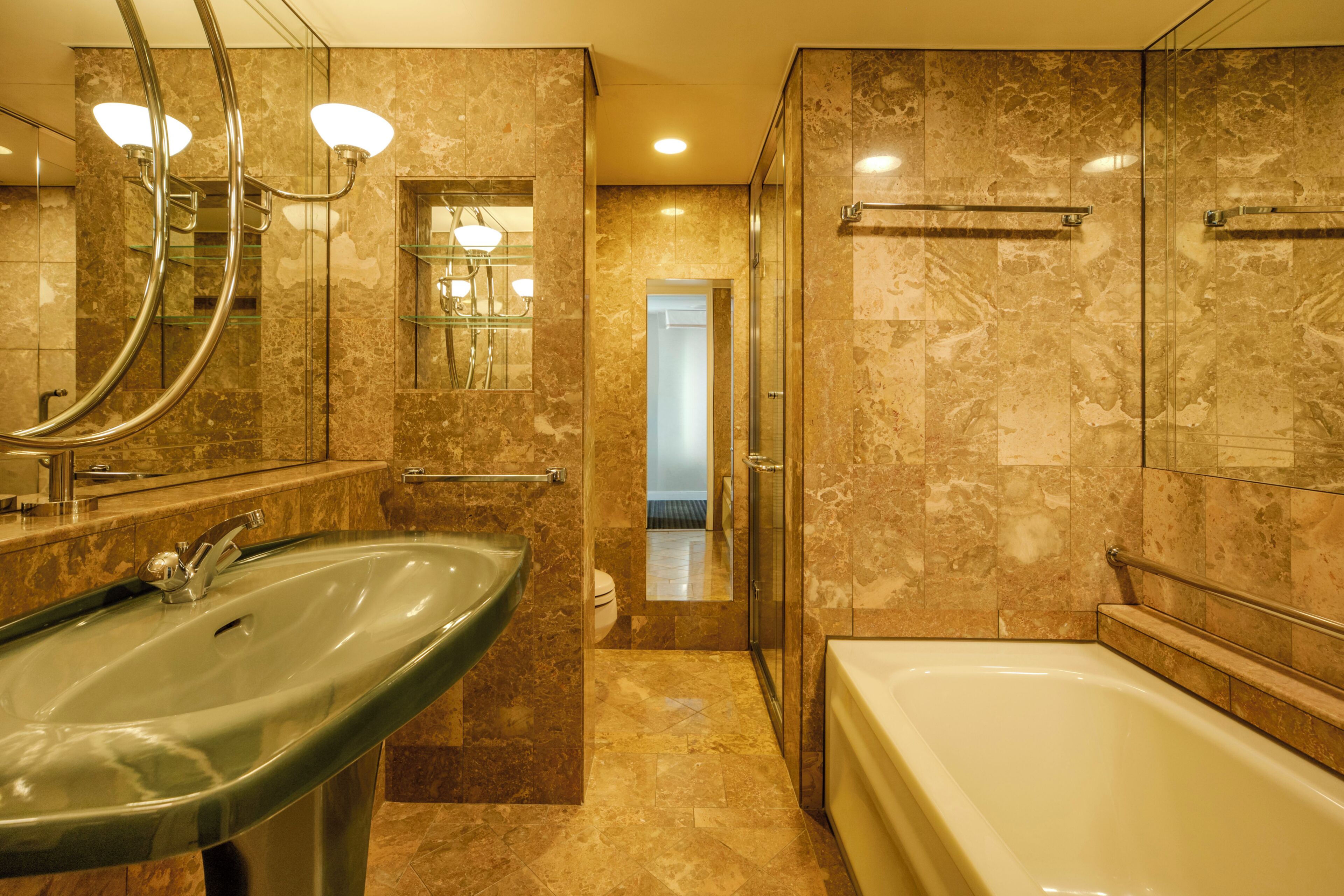 A bathroom with a large sink, a bathtub, and a shower area.