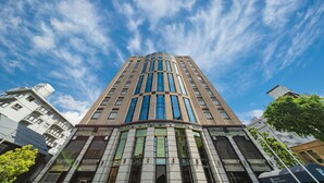 Un immeuble moderne et imposant, doté d’une façade incurvée et de grandes fenêtres.
