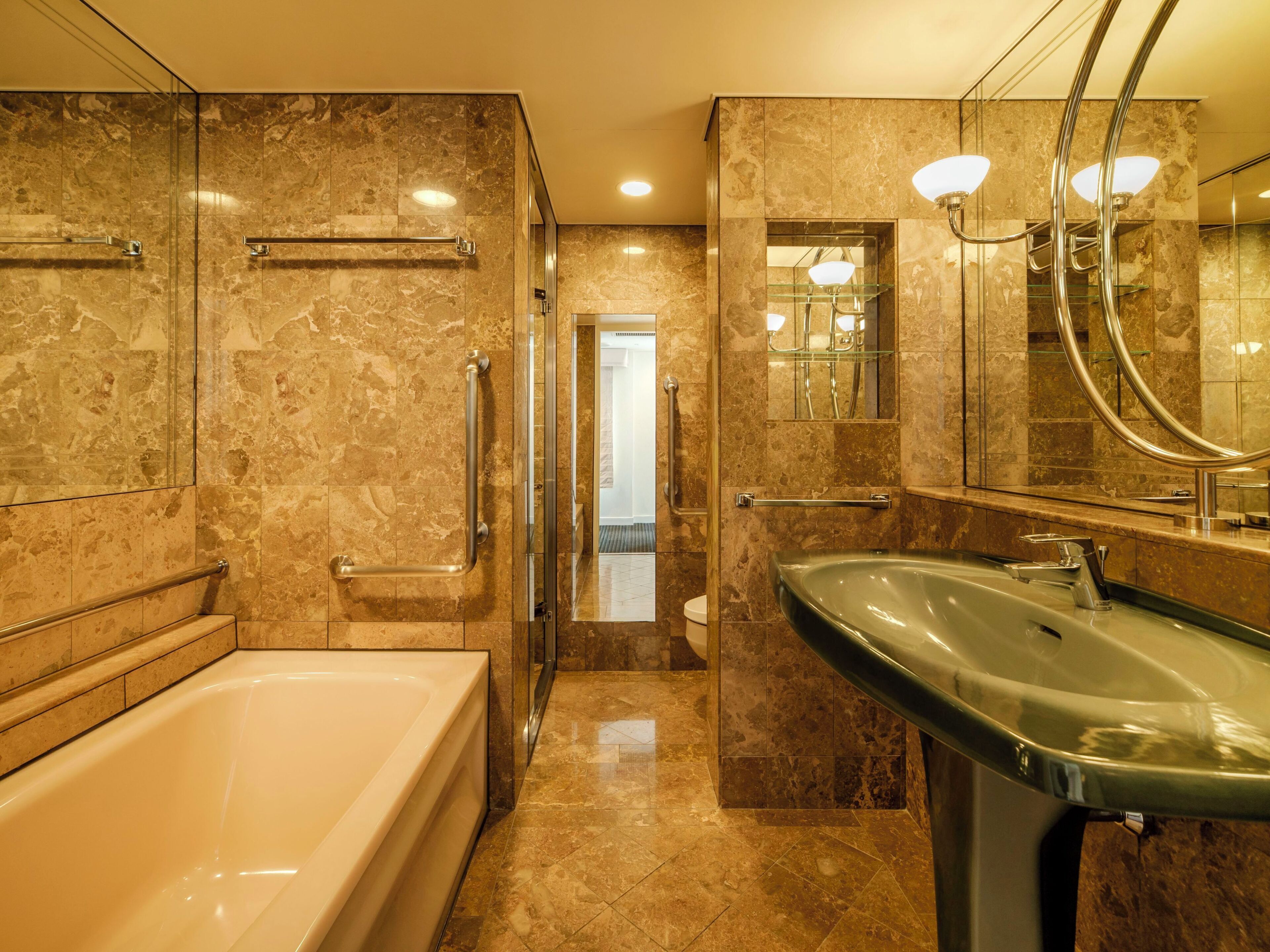 A modern bathroom with a bathtub, sink, and glass shower enclosure.