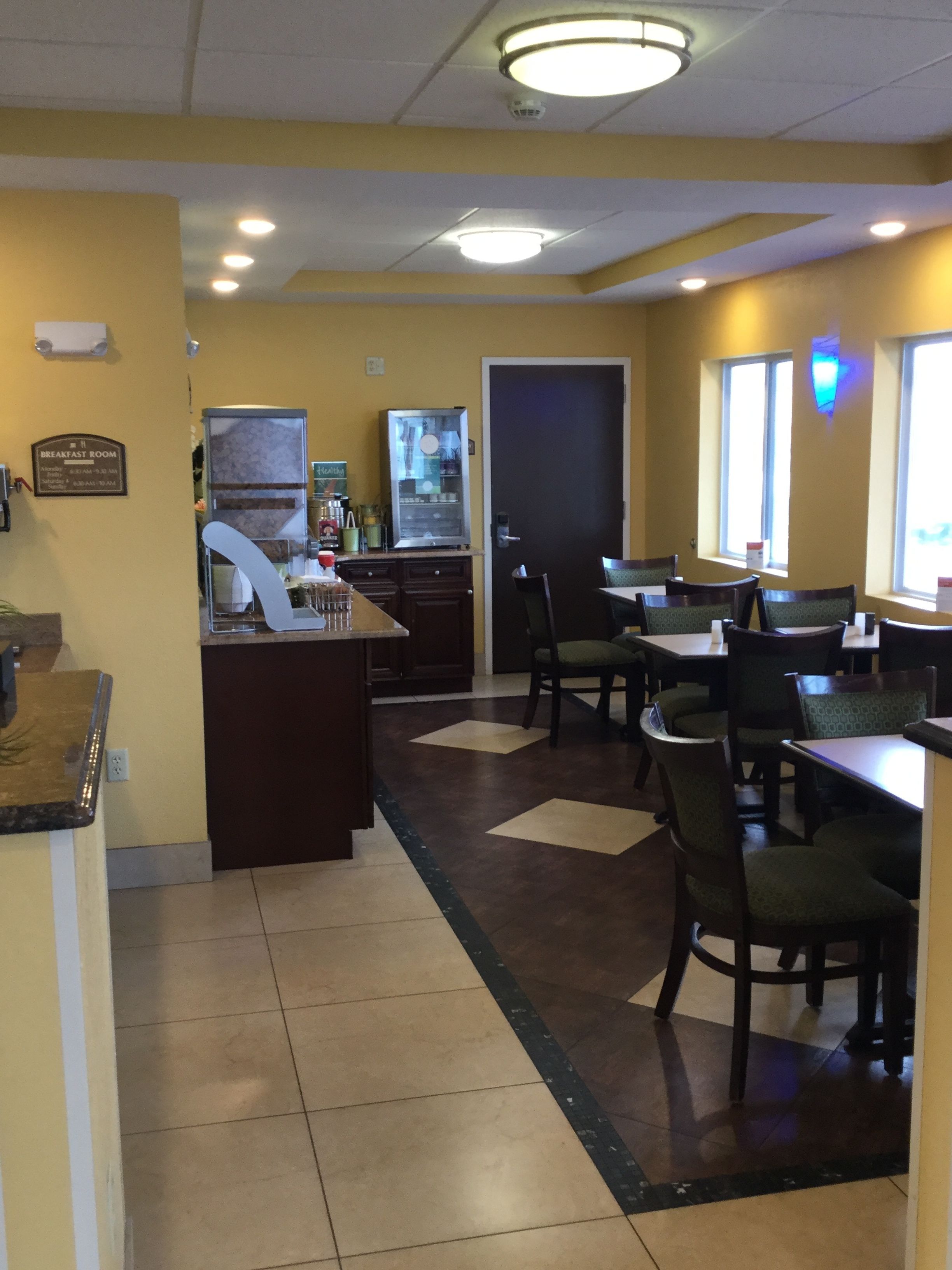 A breakfast room with a counter, chairs, and tables.