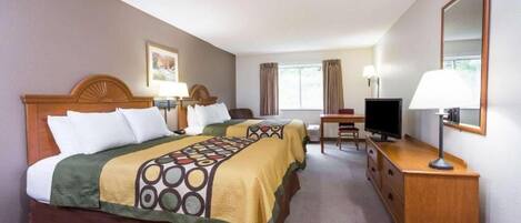 Une chambre d’hôtel avec deux lits, un bureau, une télévision et une commode.