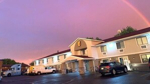 Un motel con aparcamiento, un camión y un coche.