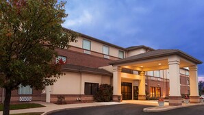 A hotel with a covered entrance, brick facade, and a landscaped driveway. - Country Inn & Suites by Radisson, Dayton South, OH (Dayton)