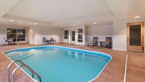 An indoor swimming pool with a tiled floor, surrounded by chairs and a door. - Country Inn & Suites by Radisson, Dayton South, OH (Dayton)