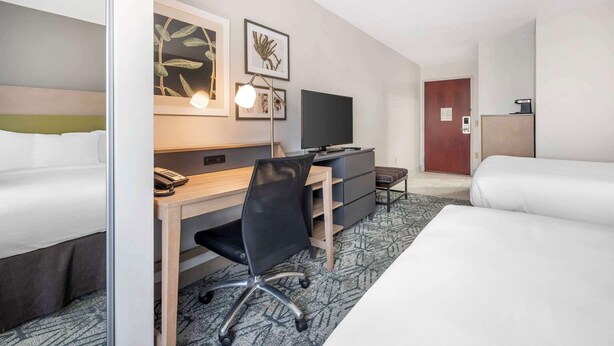 A hotel room with a bed, a desk with a computer, a chair, a TV, and a dresser. - Country Inn & Suites by Radisson, Dayton South, OH (Dayton)
