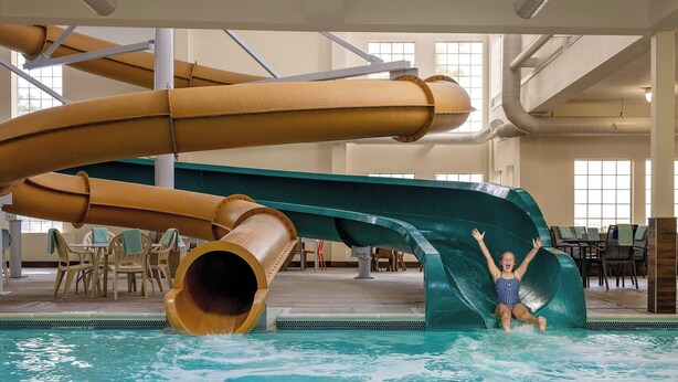 A water slide in an indoor pool area with chairs and tables around. - Fairfield by Marriott Inn & Suites Missoula Airport (Missoula)