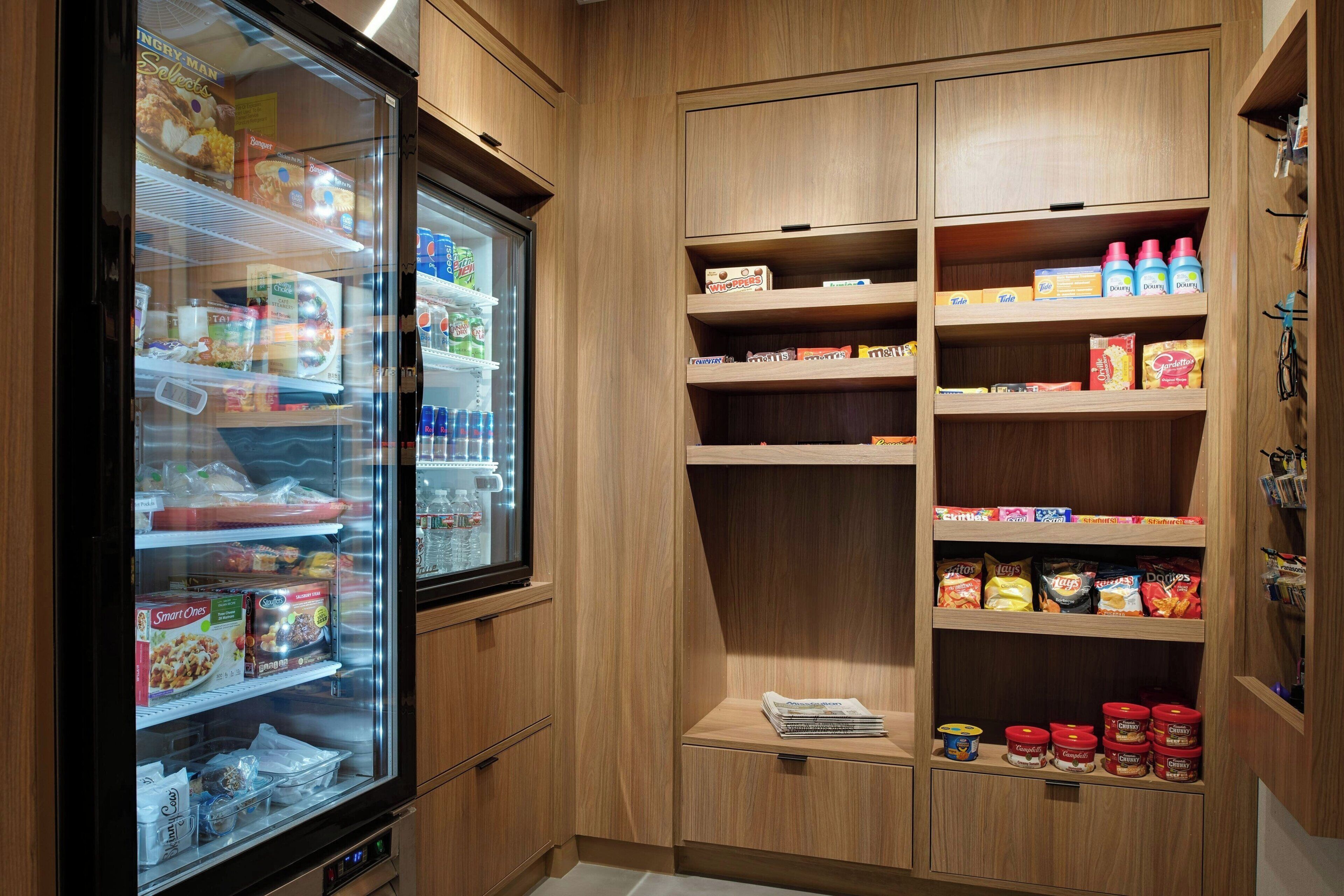 A kitchenette with a refrigerator stocked with food items, a microwave, and various kitchen appliances.