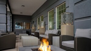 An outdoor seating area with wicker furniture, a fire feature, and decorative lamps. - Fairfield by Marriott Inn & Suites Missoula Airport (Missoula)
