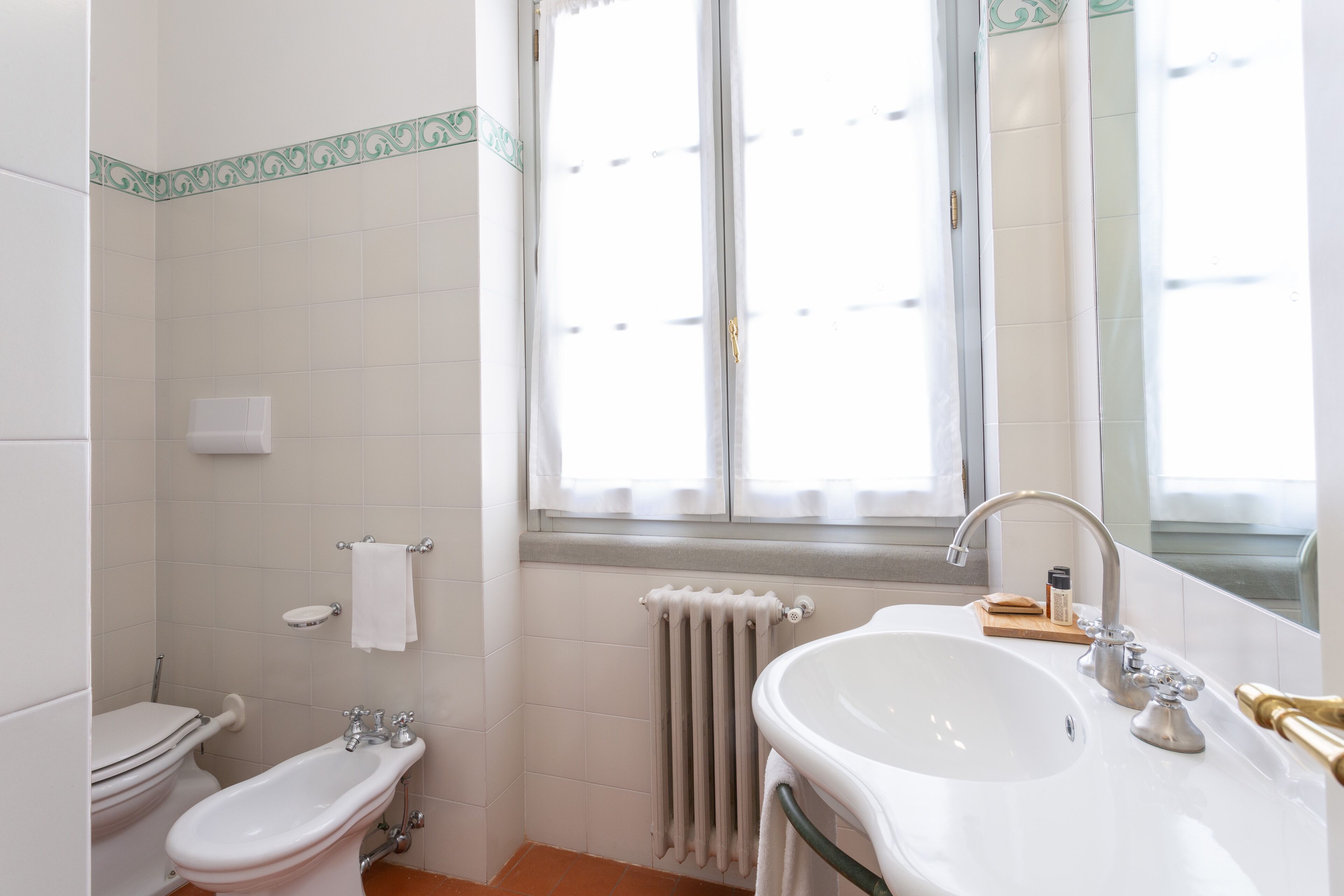 A bathroom with a toilet, bidet, and sink.