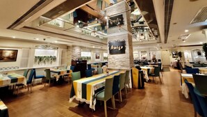 A restaurant with multiple dining areas, a piano, and a sign reading "Amigo". - Riviera Hotel Macau (Macau)