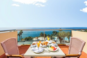 A balcony with a table set for breakfast overlooking a beach and ocean. - Pestana Viking Beach & Spa Resort (Lagoa)