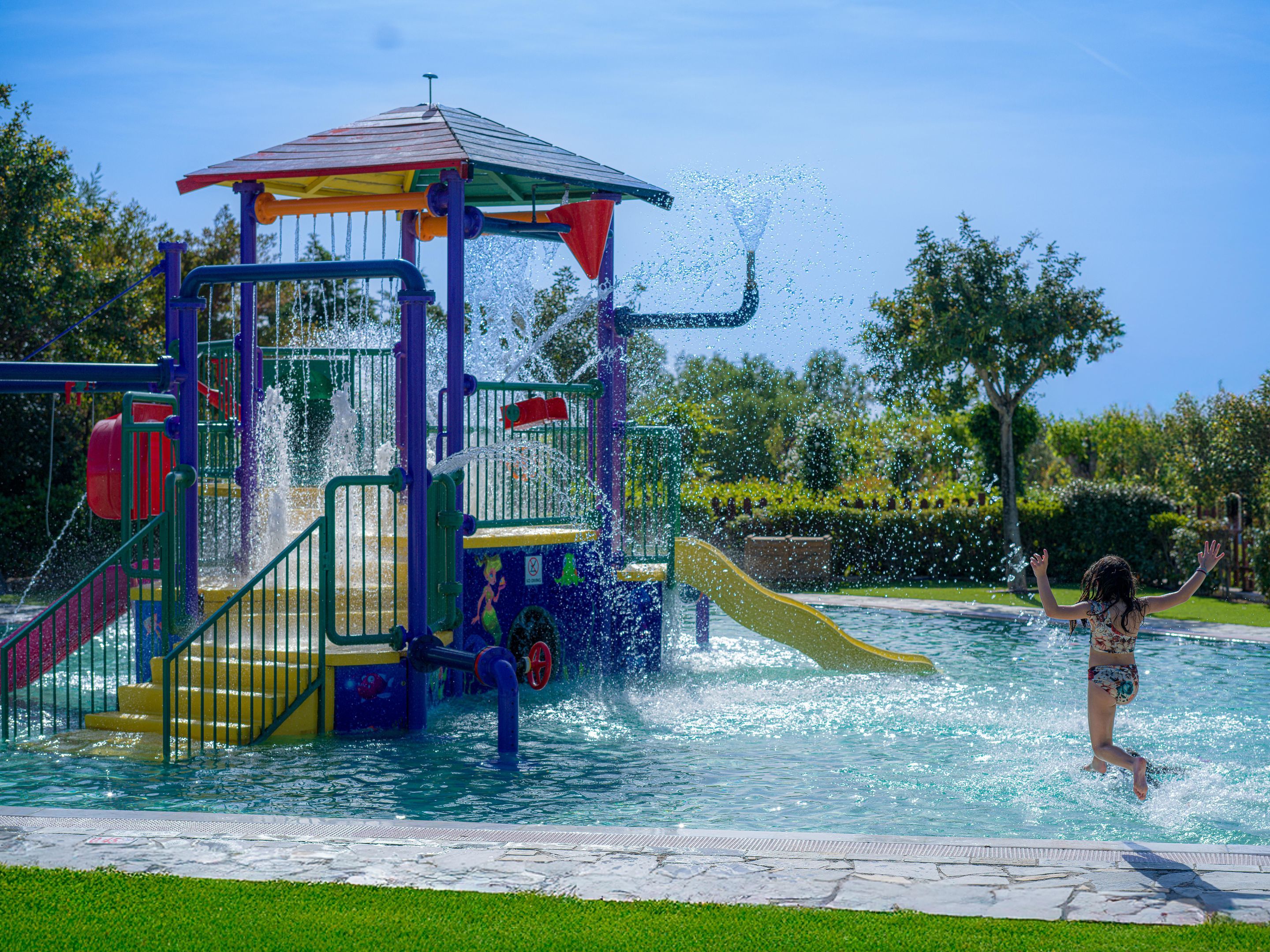 A water play area with a slide and a small structure.