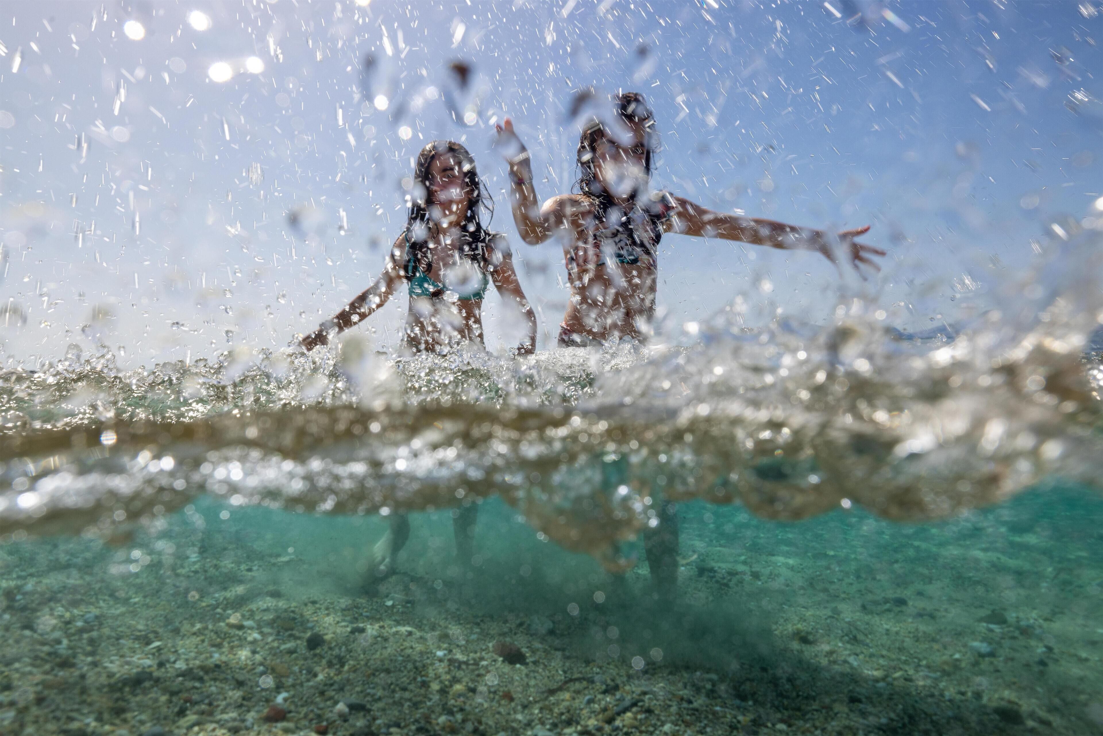 A clear view of the ocean's surface with two individuals swimming.