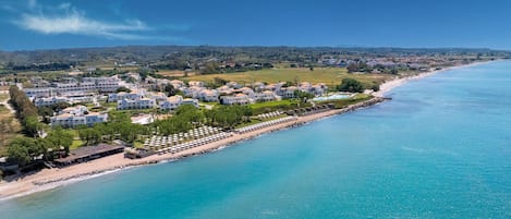 Rannalla, aurinkotuoleja, aurinkovarjoja, rantapyyhkeitä