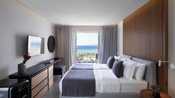 Ein modernes Hotelzimmer mit Bett, Schreibtisch, Kommode und Meerblick.