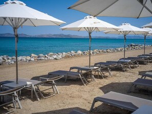 En la playa, camastros, sombrillas y toallas de playa 