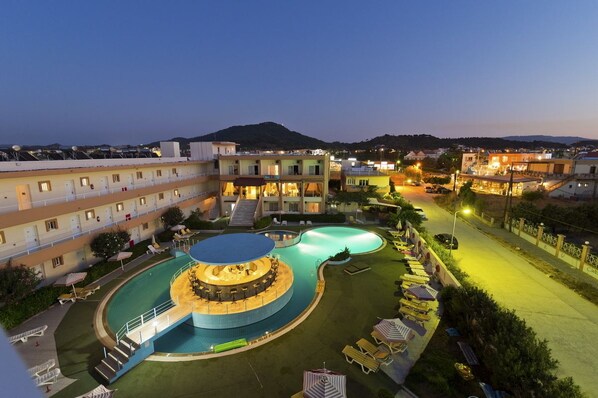 Una piscina al aire libre, sombrillas, tumbonas