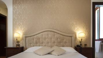 A hotel room with a large bed, two bedside lamps, and a patterned wallpaper.