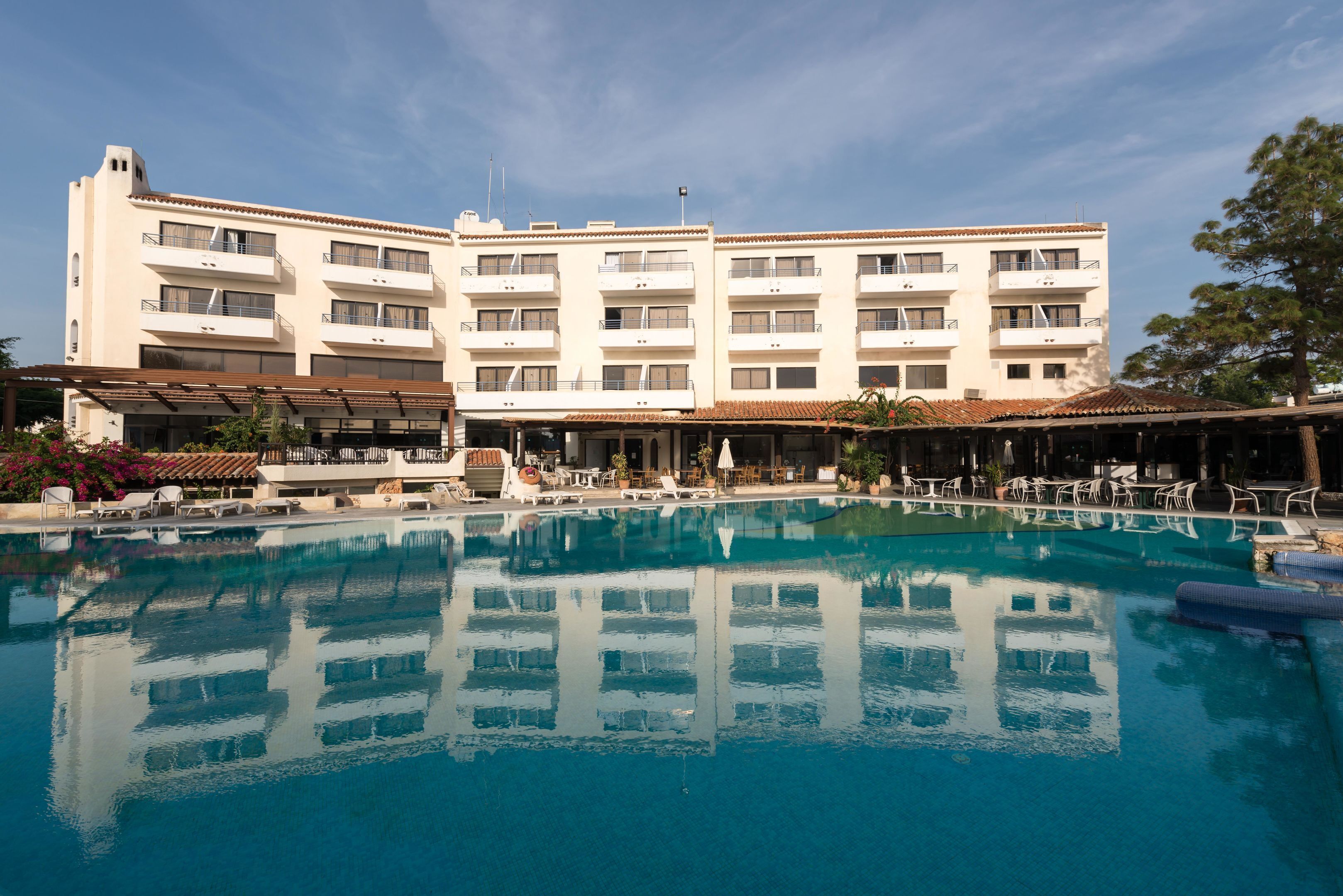 Ein Hotel mit einem großen Schwimmbad, mehreren Balkonen und Außenbereichen zum Sitzen.
