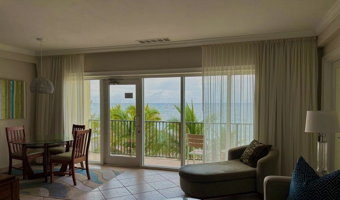 Ein geräumiges Zimmer mit Balkon, einem Essbereich und einer Sitzecke mit Meerblick.