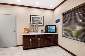 Welcome to our reception area, featuring a reception desk with a TV and framed artwork, alongside a window with a view.