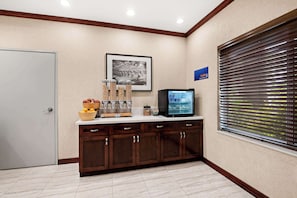 Welcome to our reception area, featuring a reception desk with a TV and framed artwork, alongside a window with a view.