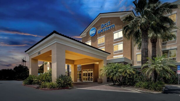 A hotel entrance with a covered area, palm trees, and a clear sky. - Best Western Ontario Mills Mall (Ontario)