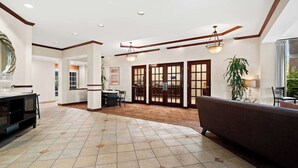 A spacious lobby with a tiled floor, a sofa, a dining area, and a large window. - Best Western Ontario Mills Mall (Ontario)