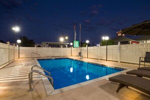 Una piscina al aire libre, sillones reclinables de piscina