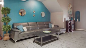 A living room with a grey sofa, a coffee table, and decorative wall art.