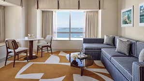 Un salon moderne avec un canapé, des fauteuils, une table basse et une vue sur la mer.