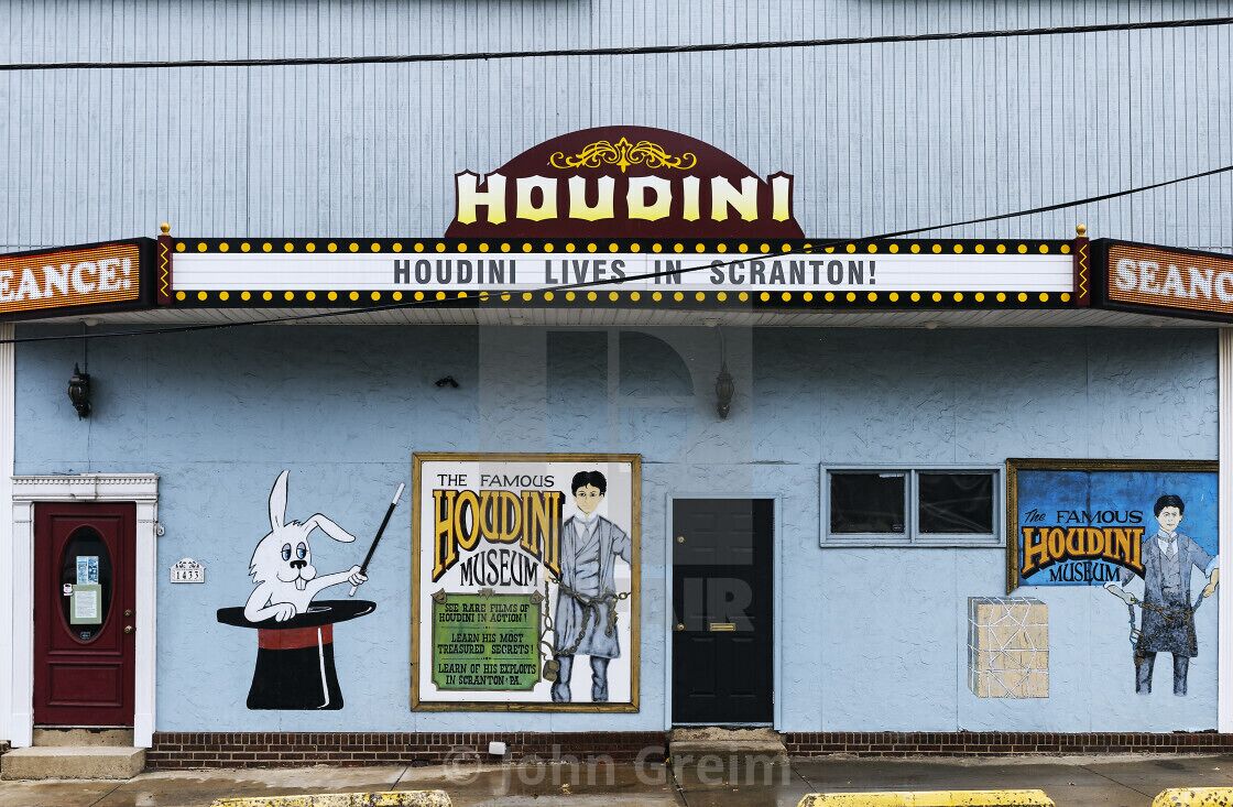 A building with a sign reading "HOUDINI" and "HOUDINI LIVES IN SCRANTON!" with a mural of a rabbit magician.