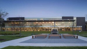A modern building with a glass facade, a central courtyard with benches, and a well-maintained lawn. - Hilton Scranton & Conference Center (Scranton)