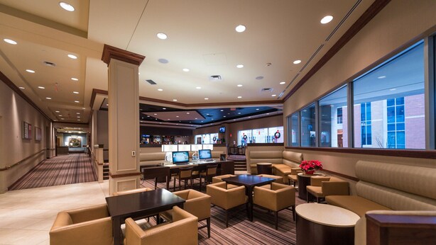 A hotel lobby with a seating area, a bar, and a view of the outside. - Hilton Scranton & Conference Center (Scranton)