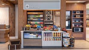 A store named 'The Shop' with a variety of chilled beverages, snacks, and dairy products. - Hilton Garden Inn Islip/MacArthur Airport (Ronkonkoma)