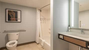 A bathroom with a toilet, shower, and sink.