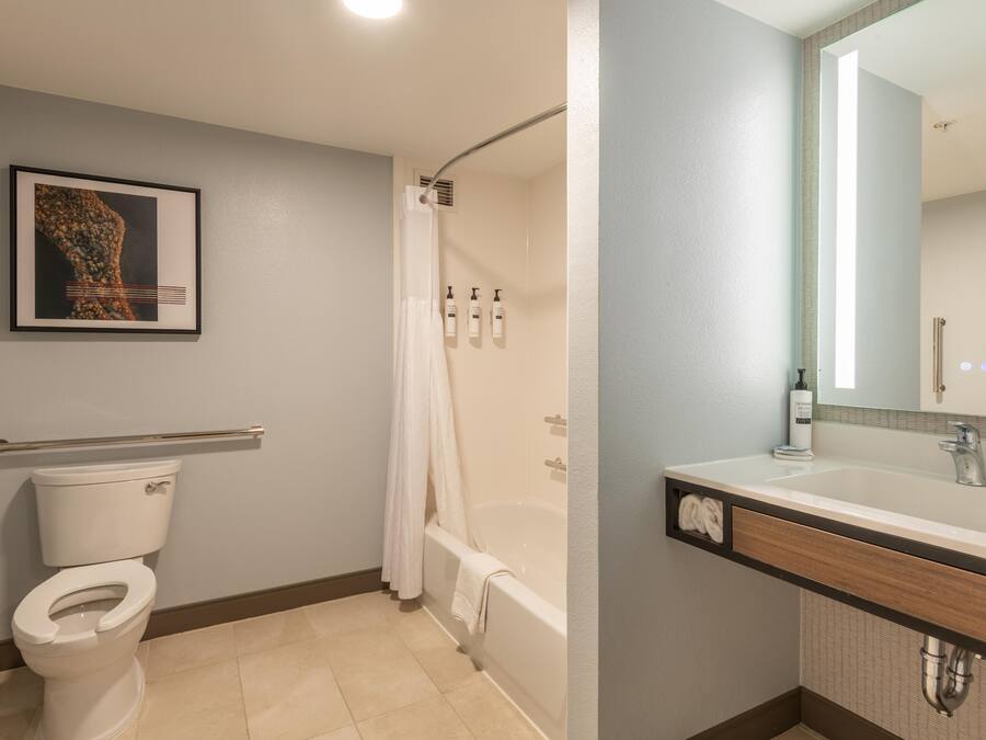 A bathroom with a toilet, shower, and sink.