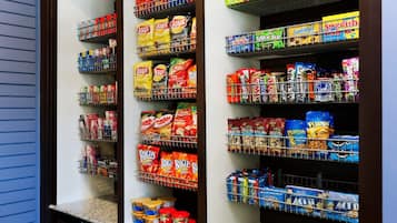 Una dispensa con ripiani pieni di snack e condimenti di vario tipo.