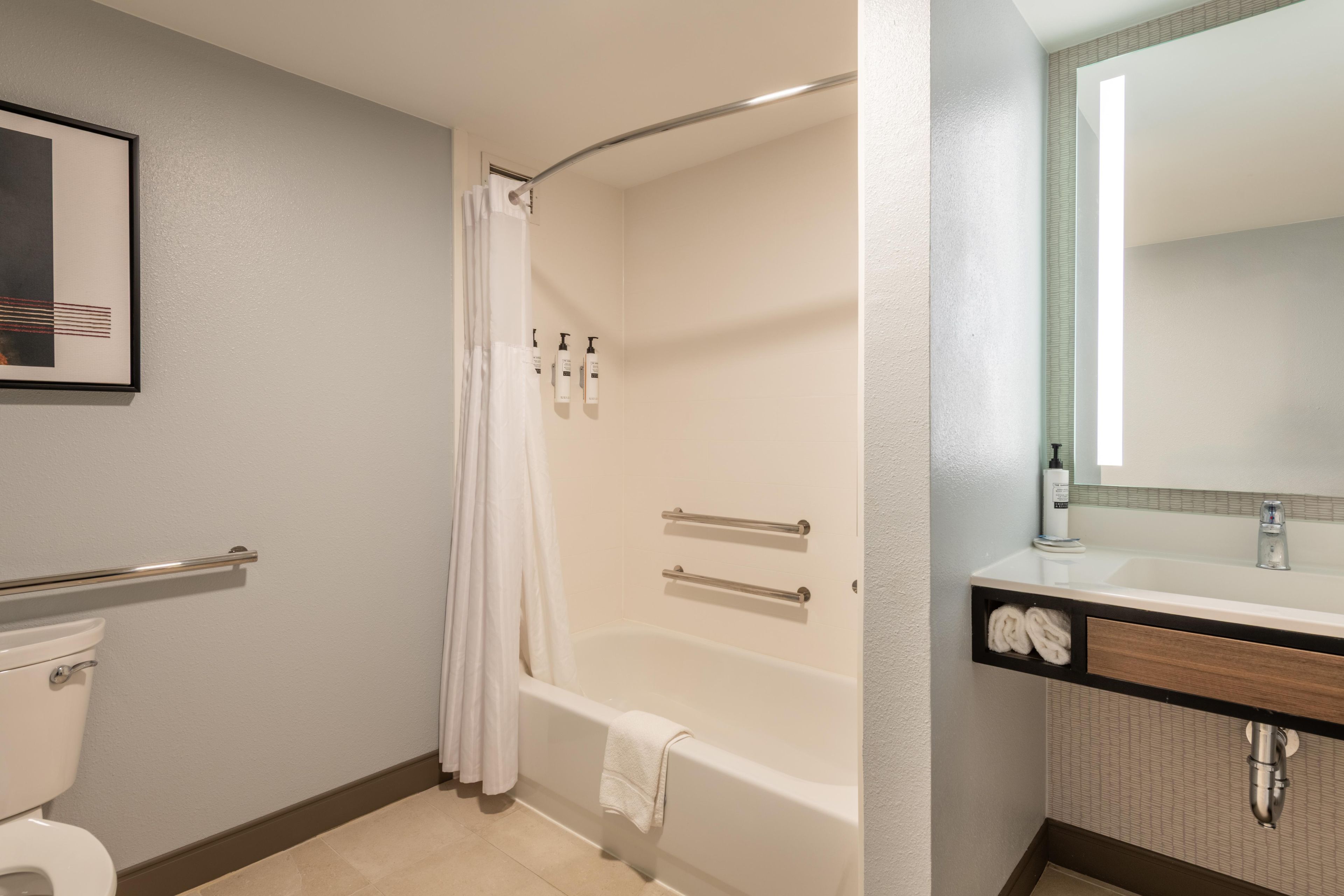 Un baño con bañera, inodoro y espejo.
