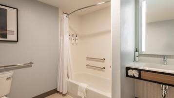 Un baño con bañera, inodoro y espejo.